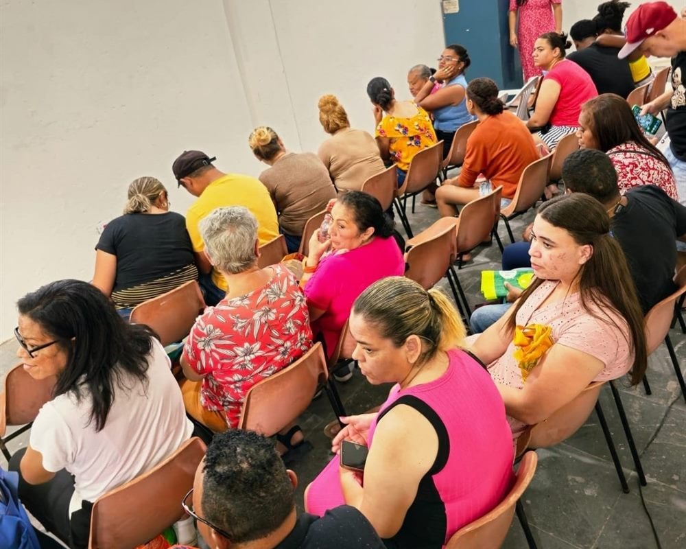Moradores atendidos no salão da sede do Instituto AMEAS durante uma ação de assistência.