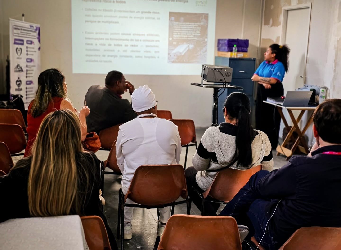Turma acompanha uma aula de capacitação com projetor na sede do Instituto AMEAS.