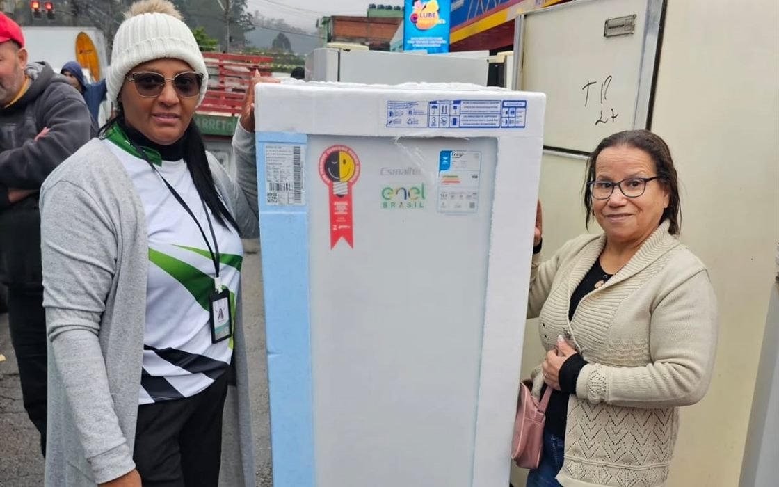 Voluntária do Instituto acompanha uma moradora na retirada de um refrigerador pelo programa habitacional Pode Entrar.